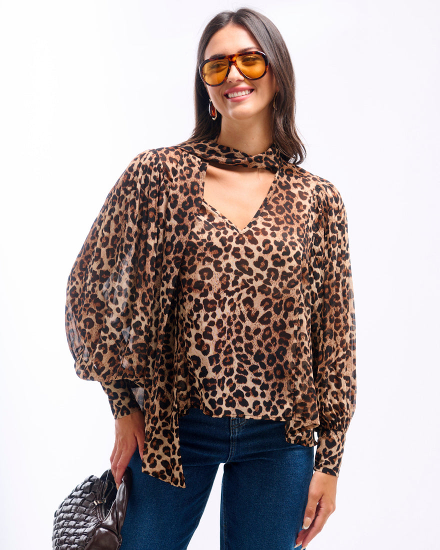 Woman wearing a leopard print blouse and sunglasses on a white background