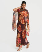 Brown floral cape maxi dress worn with the cape