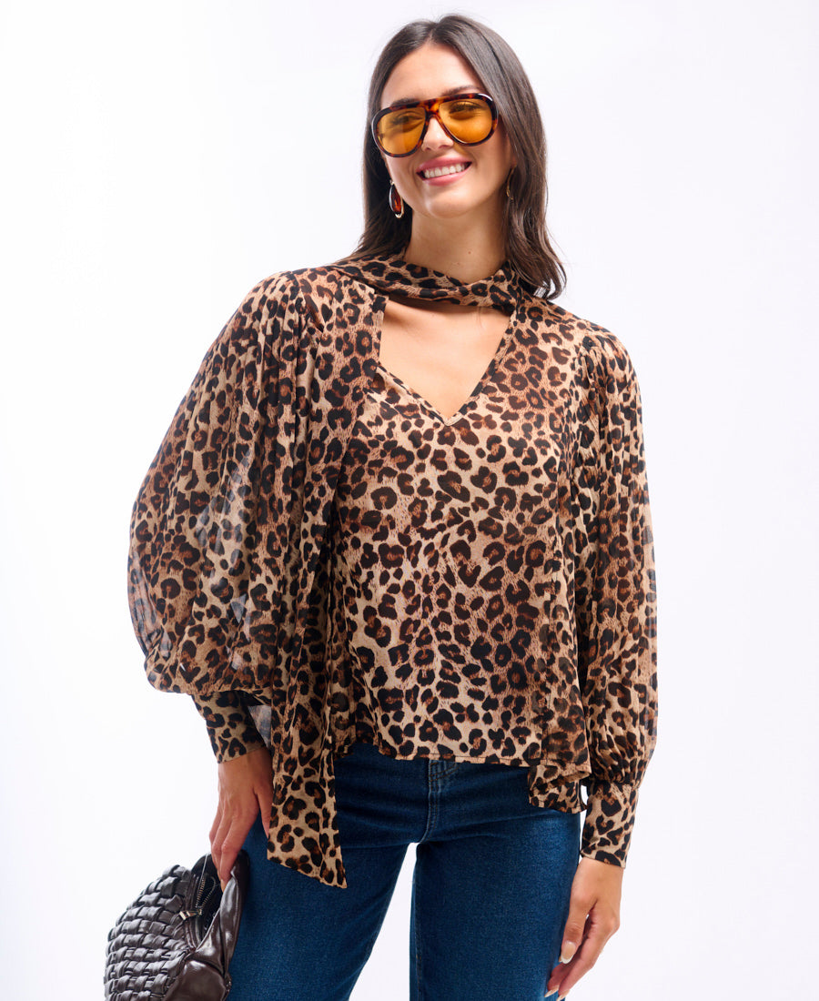 Woman wearing a leopard print blouse and sunglasses on a white background
